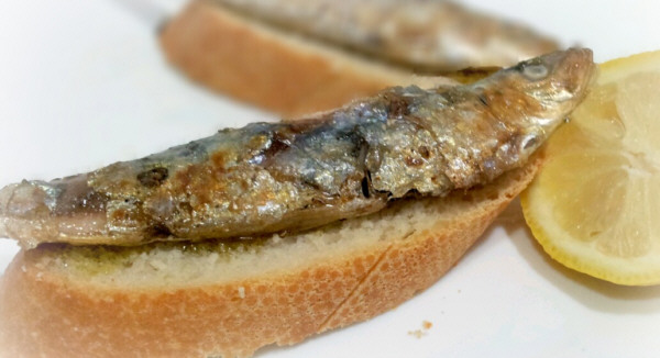 Sardinas asadas con el acompañamiento de una rebanada de pan